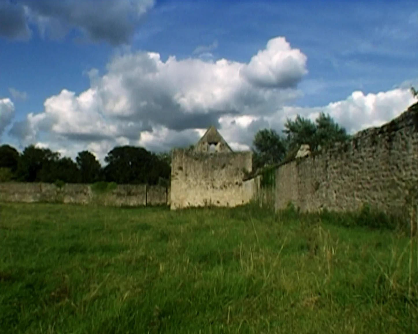 Still from the film of Silence is Golden featuring a long shot of Godstow Nunnery and surrounding fields on a sunny day.